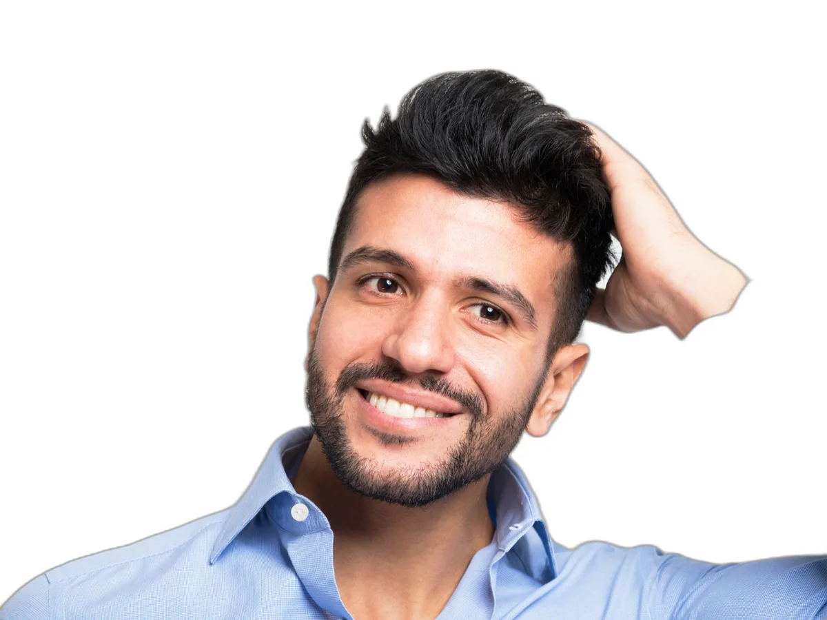 Smiling man running a hand through thick dark hair — hair restoration