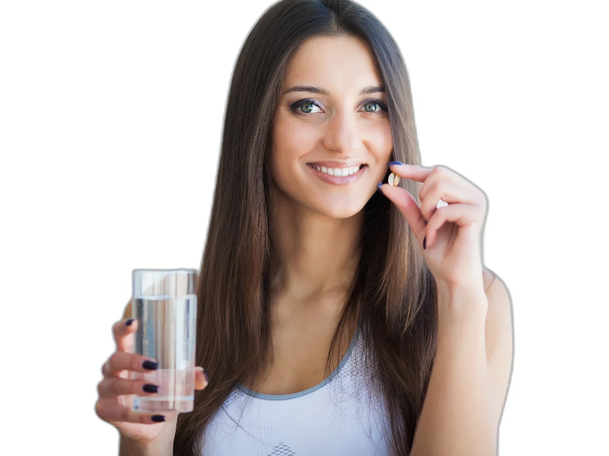 Smiling woman taking a supplement with a glass of water — physician-grade supplements